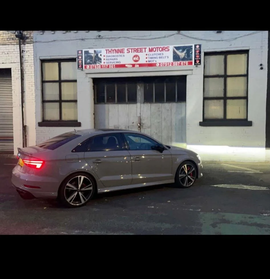 Silver Audi parked outside the Thynne Street Motors garage in the evening