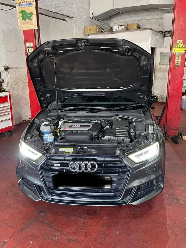 Audi with bonnet raised in the garage